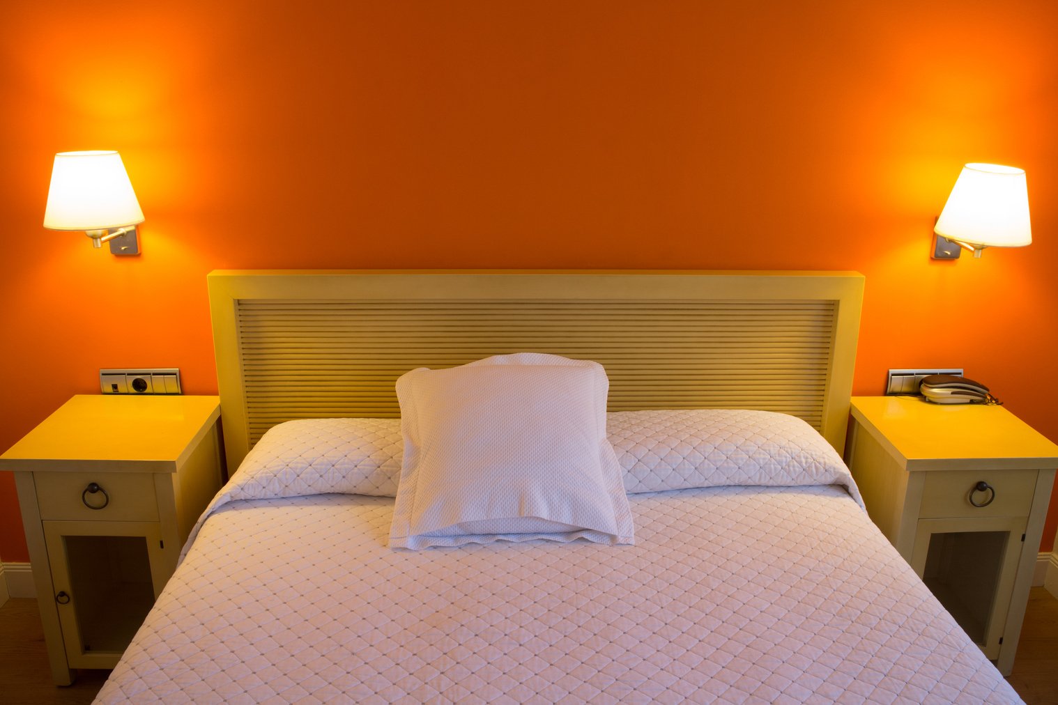 Queen sized bed in colorful orange room