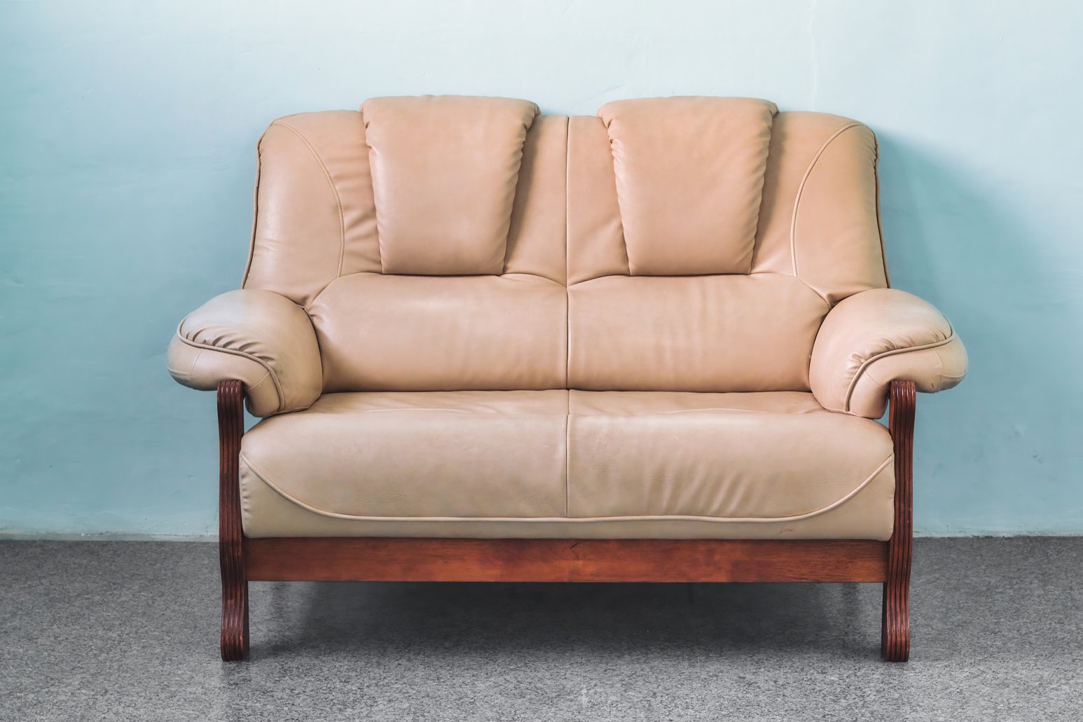 1950s Beige leather 2-seater sofa in a simple stark interior living room in a cozy apartment